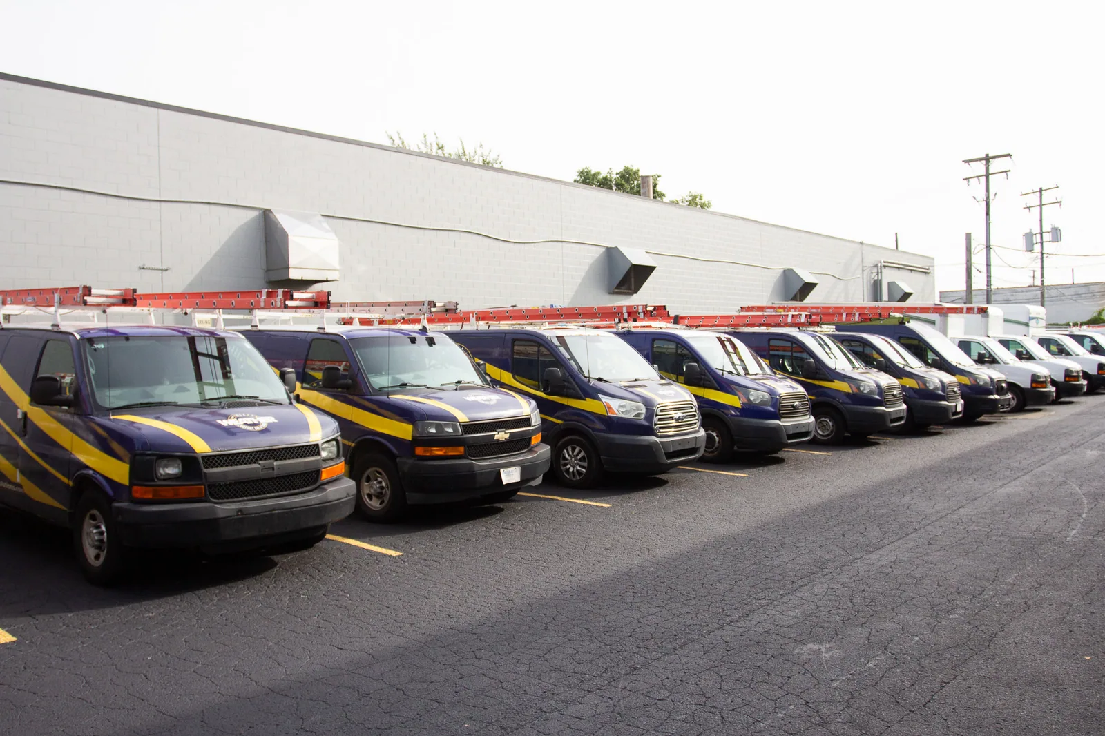 All Weather Comfort Solutions service vans lined up outside the shop