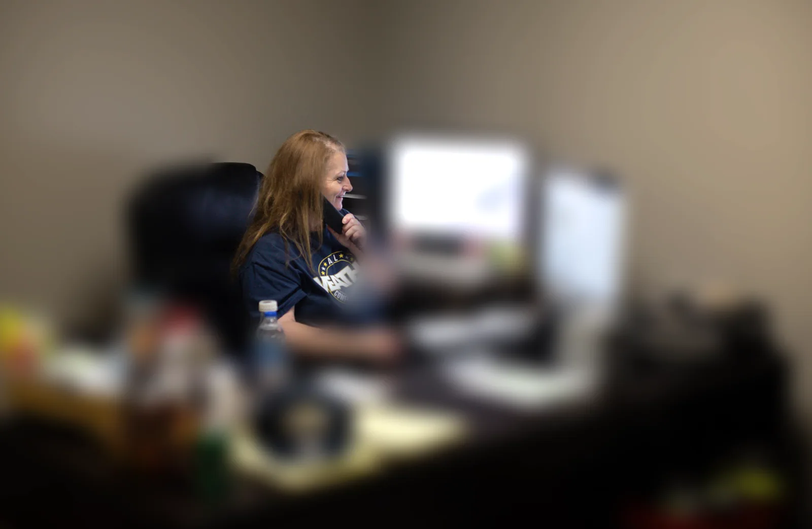 An All Weather Comfort Solutions staff member answering the phone at her desk