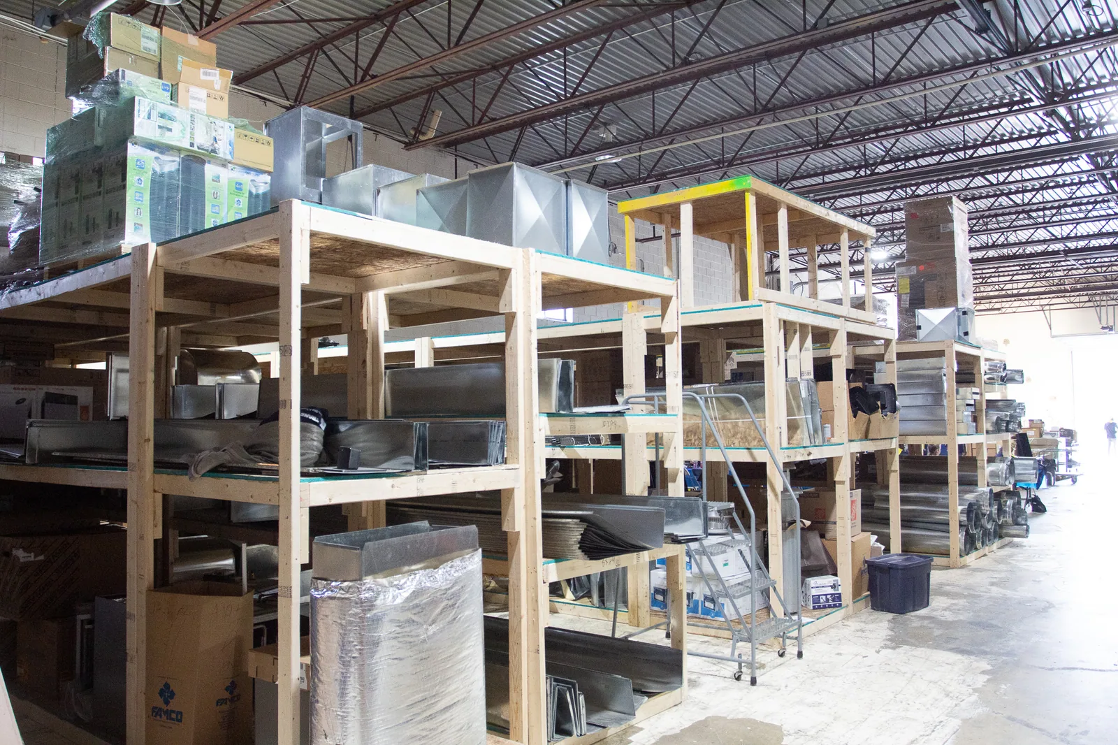 Warehouse shelving loaded with HVAC parts at the All Weather shop