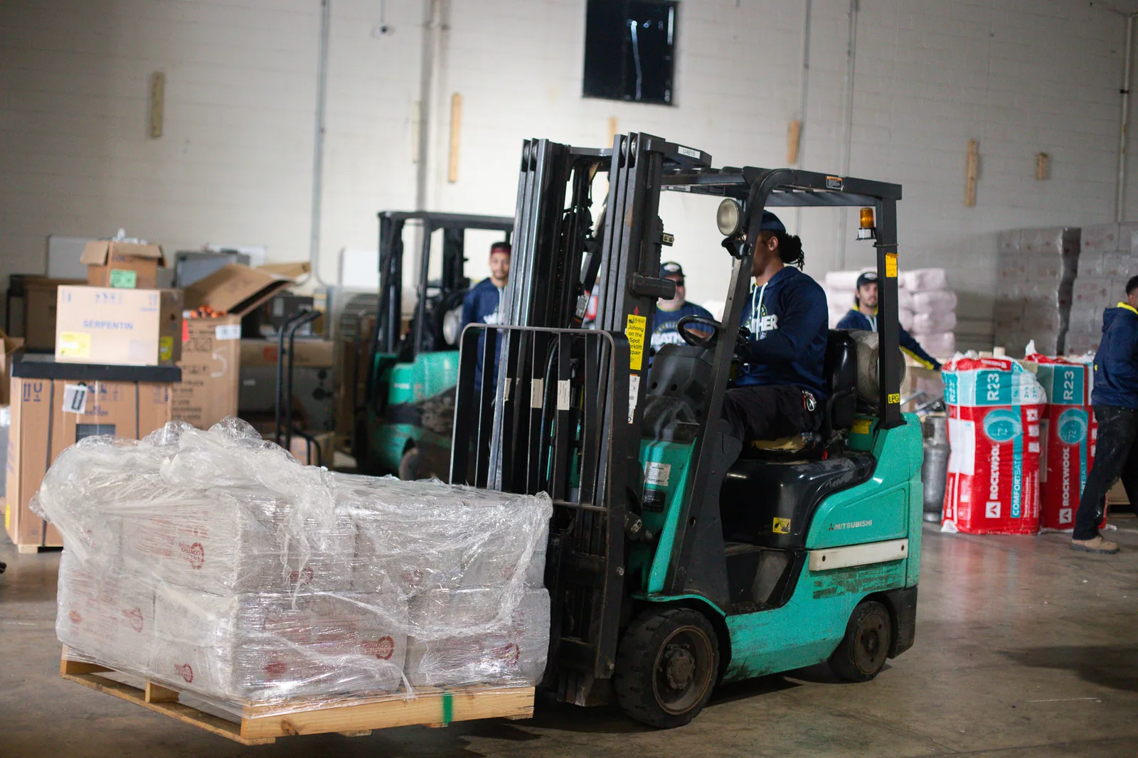 Team member operating a forklift to move equipment in the warehouse